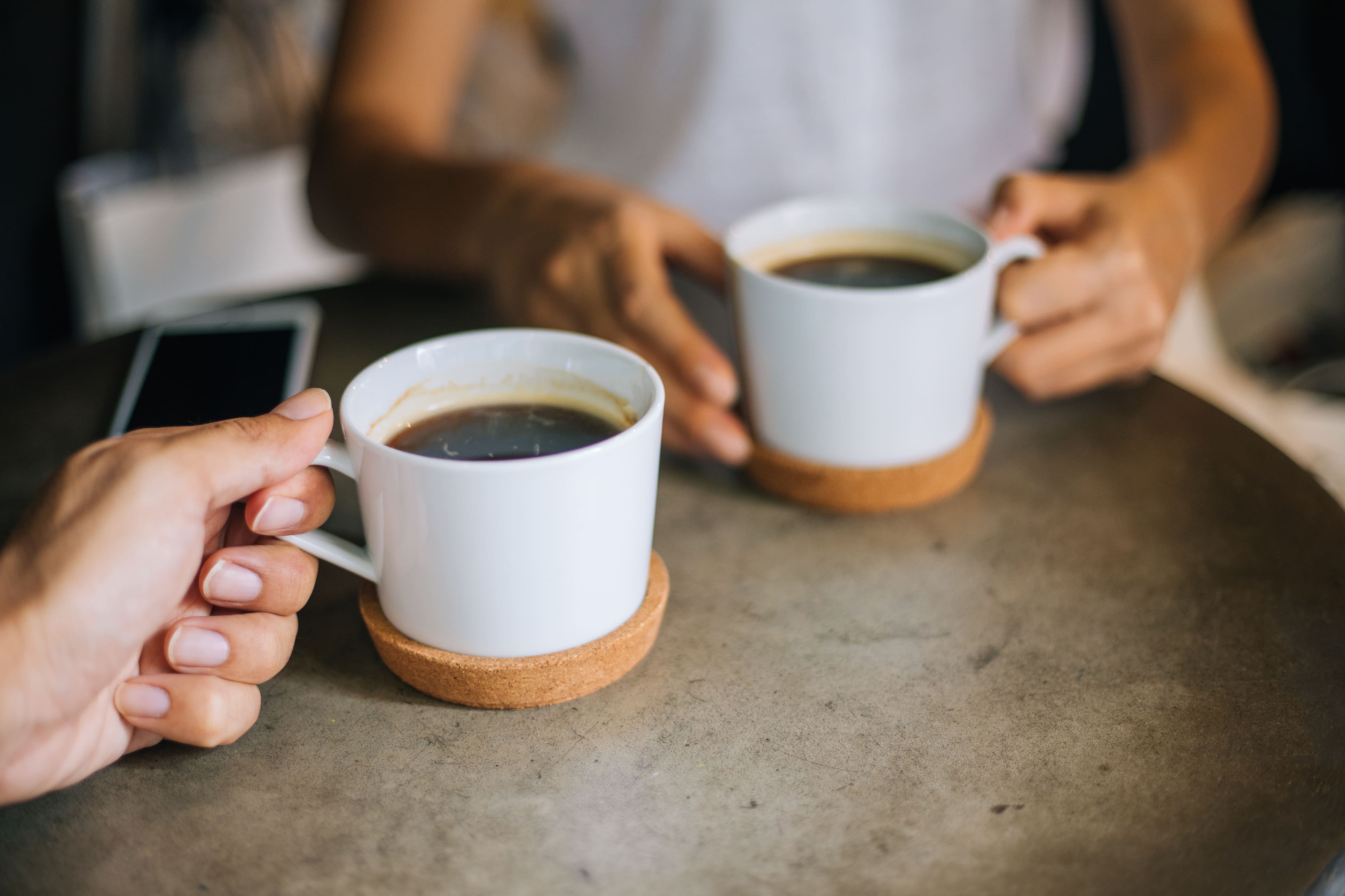 Zwei Personen, Kaffeetassen haltend